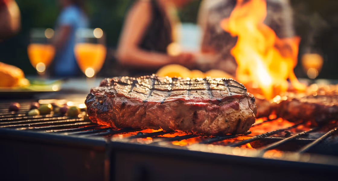 Grilled steak with grill marks served with green beans on a white plate with a red cloth in the background.
